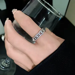 Primer plano detallado del elegante diseño de ondas de un anillo de circonita y perlas