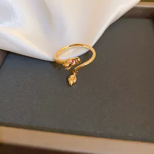 Dettaglio ravvicinato di un anello a forma di drago dorato con occhi in zircone rosso
