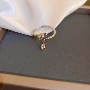 Primo piano di un anello a serpente in argento con occhio di zircone e foglia