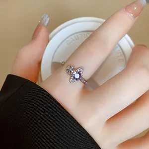 Dettagliato primo piano di un anello a forma di Saturno con zircone viola al dito