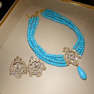 Vintage multi-strand turquoise bead necklace and earring set with ornate gold pendant