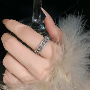 Primer plano detallado de un elegante anillo abierto en forma de ola con circonitas.