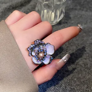 Vintage floral cocktail ring with faux pearls and sparkling blue rhinestones on hand