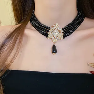 Close-up of elegant vintage multi-layer black pearl choker necklace with crystal pendant