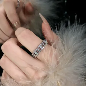 Primer plano de un elegante anillo abierto ondulado con circonitas y perlas en el dedo