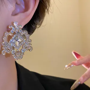 Detailed close-up of an ornate vintage baroque style gold earring with sparkling rhinestones