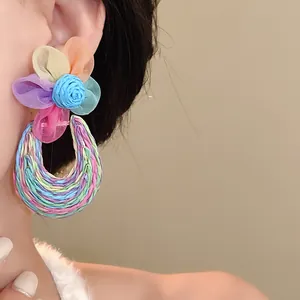 Detailed close-up of colorful bohemian mesh flower earrings for summer beach vacation