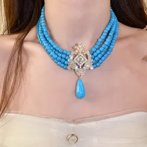 Close-up of vintage palace style multi-strand turquoise bead necklace with ornate pendant