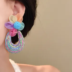 Macro detail view of colorful mesh flower earrings with woven bohemian style horseshoe hoop
