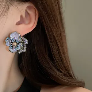 Detailed view of vintage flower stud earrings with pearls and colorful crystals