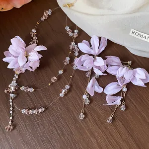 Detail of a light purple fabric flower jewelry set with elegant pearls and crystal beads