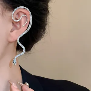 Gros plan d'une boucle d'oreille en forme de serpent ornée de strass sur un modèle