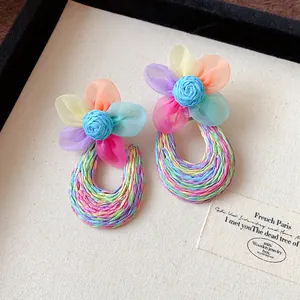 Detailed view of bohemian mesh flower earrings with a vibrant multicolored woven base.
