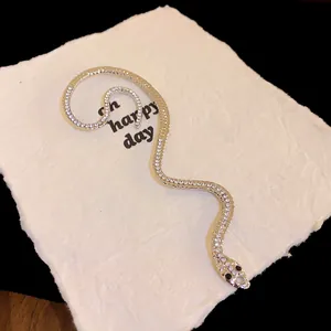 Vue détaillée d'un protège-oreille serpent plaqué or avec des strass étincelants.