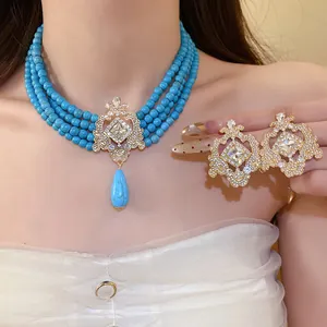 Close-up detail of vintage palace-style turquoise necklace and ornate crystal earrings set