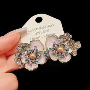 Detail view of elegant floral earrings with pink enamel, pearls and rhinestones