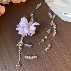 Close-up detail of elegant purple fabric flower necklace with delicate crystal beads