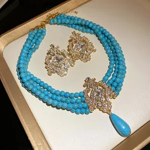 Vintage turquoise style multi-layer beaded necklace and earring set on a gold tray