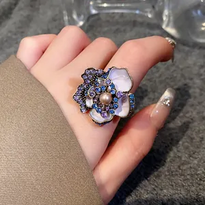 Detailed close-up of a vintage flower ring featuring purple rhinestones and a central pearl
