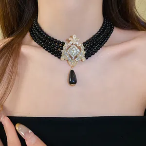 Close-up of vintage palace style multi-layer black beaded choker with teardrop pendant