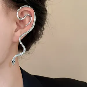 Gros plan d'un earcuff serpent étincelant en strass sur l'oreille d'un mannequin