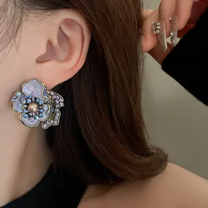 Detailed macro view of vintage flower earrings with colorful rhinestones and central pearl