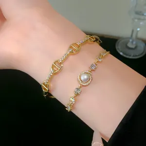 Detailed view of gold-plated pig nose link bracelet with pave zircons and pearl accents
