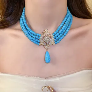 Detail view of vintage turquoise beaded multi-layer necklace with ornate crystal pendant