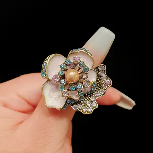 Detailed view of vintage flower earrings with central pearl and colorful crystal rhinestones