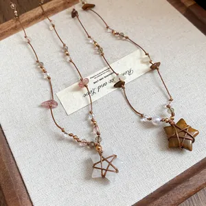 Gros plan détaillé de colliers pendentifs étoile vintage avec des pierres d'oeil de tigre