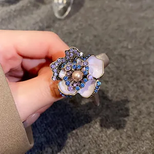 Detailed view of vintage flower stud earring featuring central pearl and rhinestones