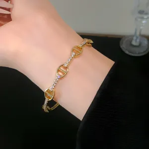 Detailed close-up of a gold-plated pig nose bracelet set with sparkling cubic zirconia