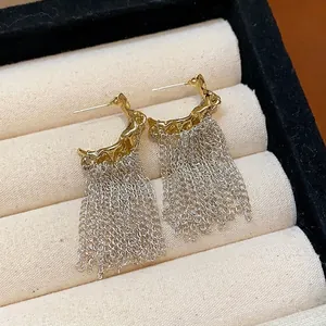 Elegant minimalist bicolor stud earrings featuring gold lava studs and silver chain tassels