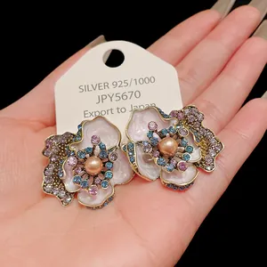 Close-up of vintage flower earrings with pearls and colorful rhinestones