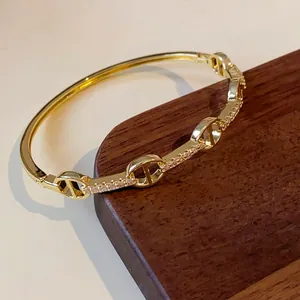 Close-up view of gold-plated pig nose link bangle with sparkling cubic zirconia stones