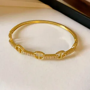 Close-up detail of a gold-plated pig nose bangle bracelet featuring zircon inlay.