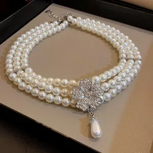 Elegant multi-layer pearl necklace with a rhinestone flower pendant and teardrop pearl