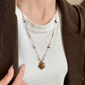 Gros plan d'un collier vintage avec pendentif étoile en œil de tigre sur un mannequin