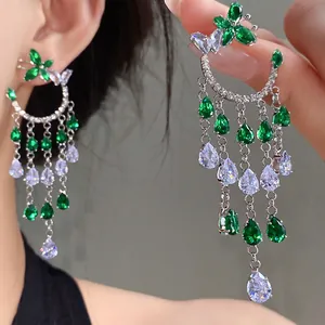 Close-up of elegant silver earrings with green butterfly and sparkling zircon tassels.