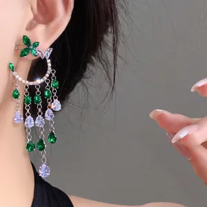 Detailed view of elegant silver needle earrings with green zircon butterfly and tassels.