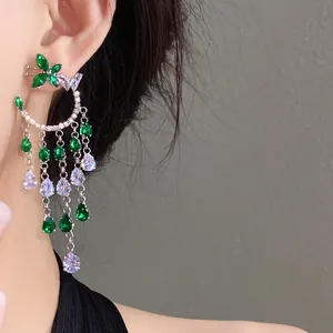 Detailed view of elegant green and purple zircon butterfly tassel earrings worn on an ear