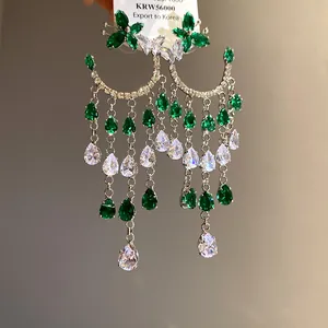 Detailed view of luxurious green zirconia butterfly and crescent teardrop tassel earrings