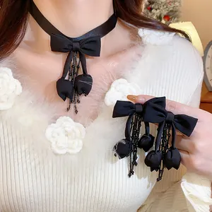 Dettaglio del set collana e orecchini con fiocco in tessuto nero e nappe