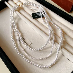 Dettaglio ravvicinato di una collana di perle finte multistrato in stile francese in un vassoio