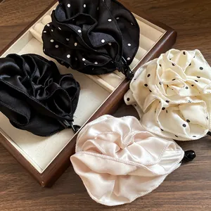 Dettaglio di quattro eleganti fermagli per capelli a fiore in tessuto a pois