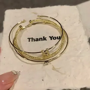 Elegante bracciale rigido aperto placcato in oro con design a lettera H e zirconi
