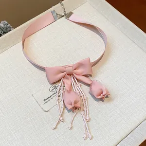 Elegante girocollo in nastro rosa con fiocco in tessuto e delicati dettagli di nappine