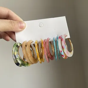 Dettaglio ravvicinato di set di orecchini a cerchio in acrilico colorato con motivi marmorizzati
