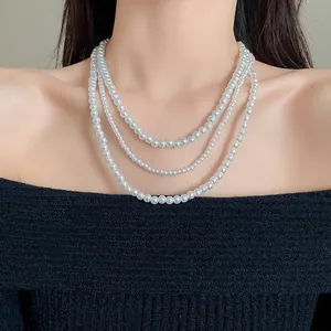 Elegante collana a tre strati di perle finte sul collo di una modella