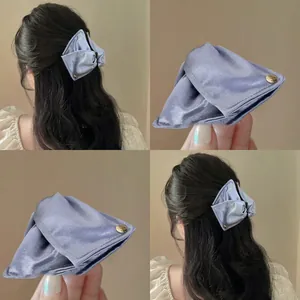 Elegante molletta per capelli a triangolo in raso blu polvere con bottone dorato.